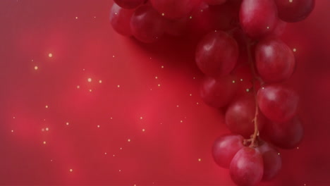 composition of spots of light over red grapes on pink background