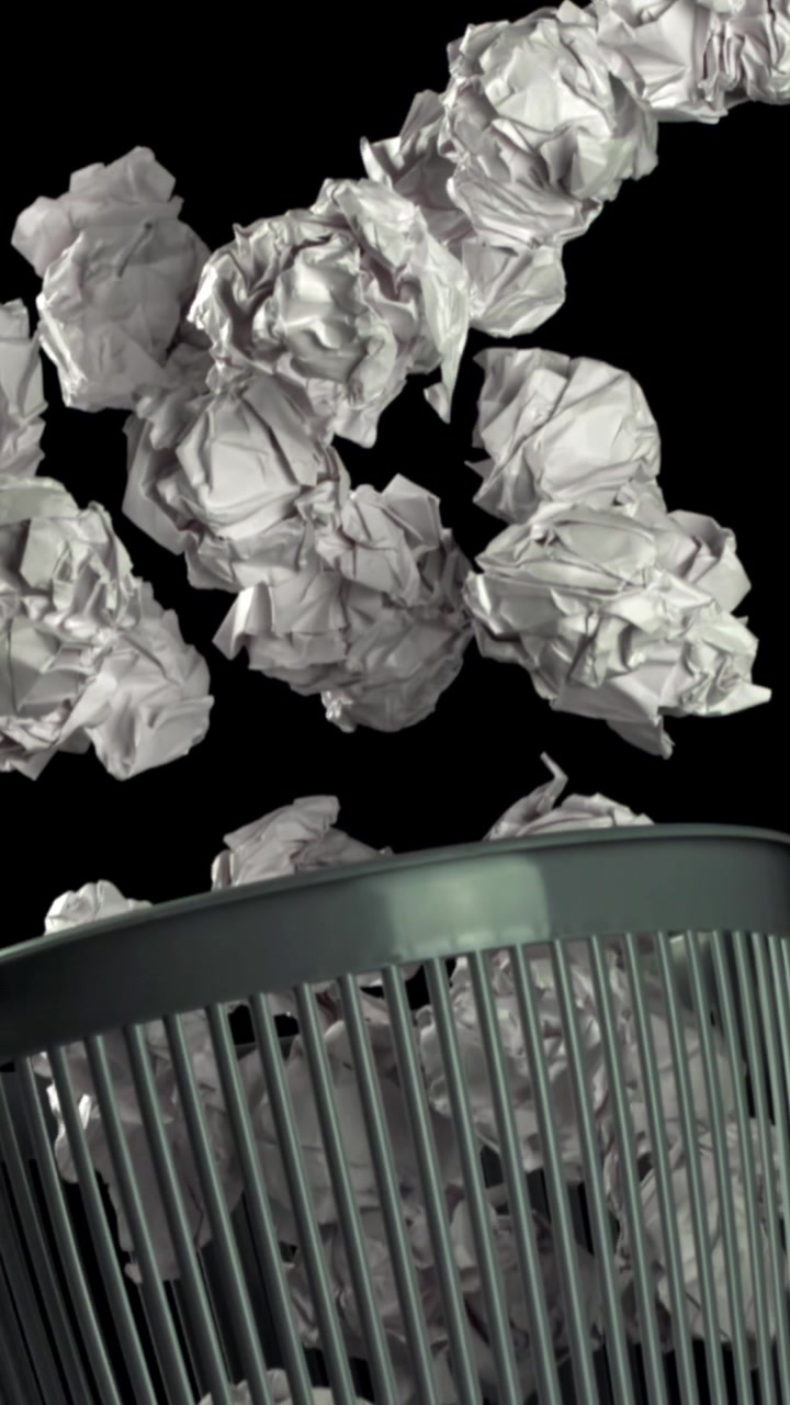Carta accartocciata che cade in un cestino della spazzatura straripante