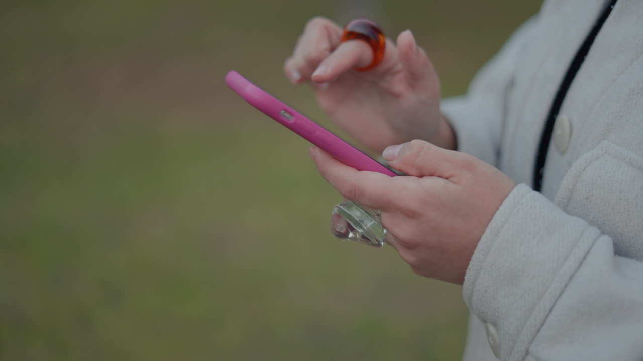 야외에서 스마트폰을 사용하는 여성