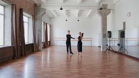 couple practicing ballroom dance in a spacious studio