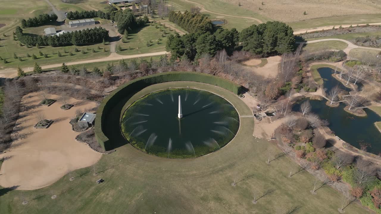 fuente de agua épica en el jardín, el retroceso aéreo de arriba hacia abajo revela la belleza bien mantenida y el asombroso paisaje natural de australia