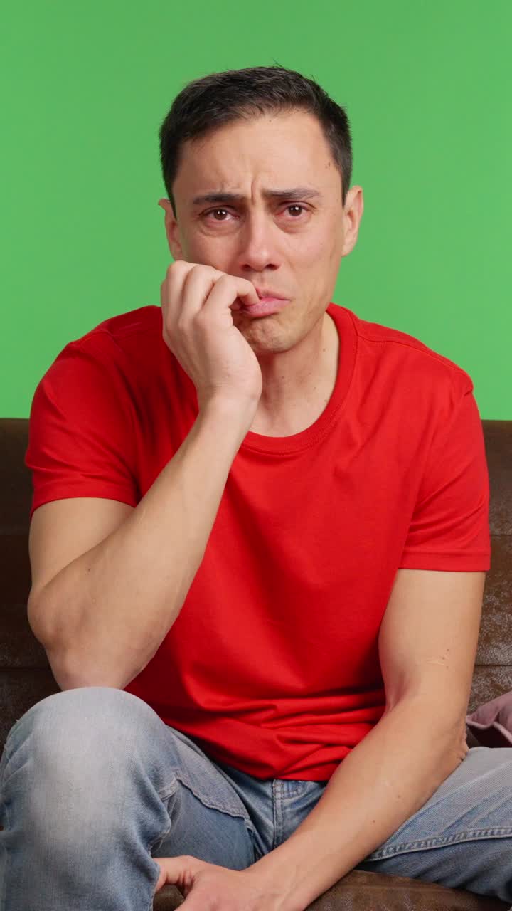 Sad man crying watching a movie on green screen background