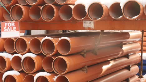 orange pvc pipes stacked in construction site