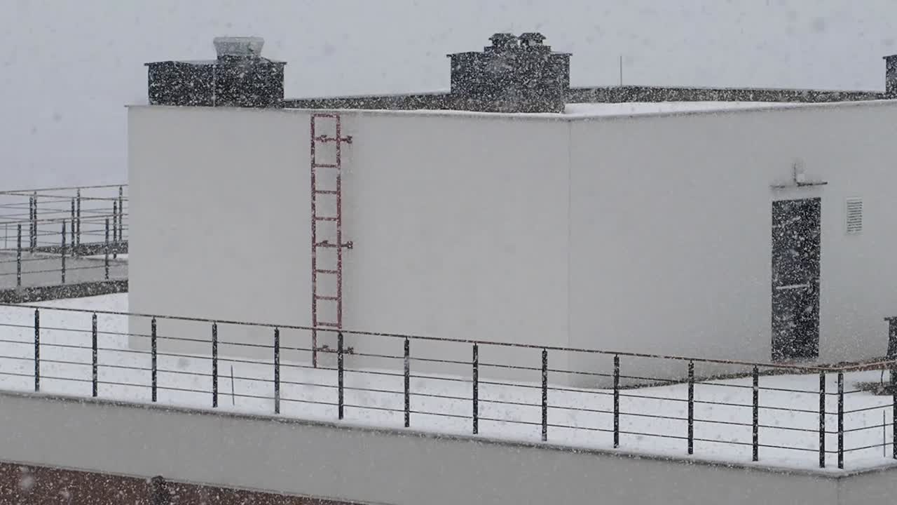Snowy building exterior with ladder