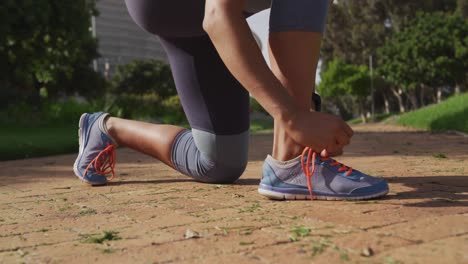 caucasian woman preparing for a run in a park