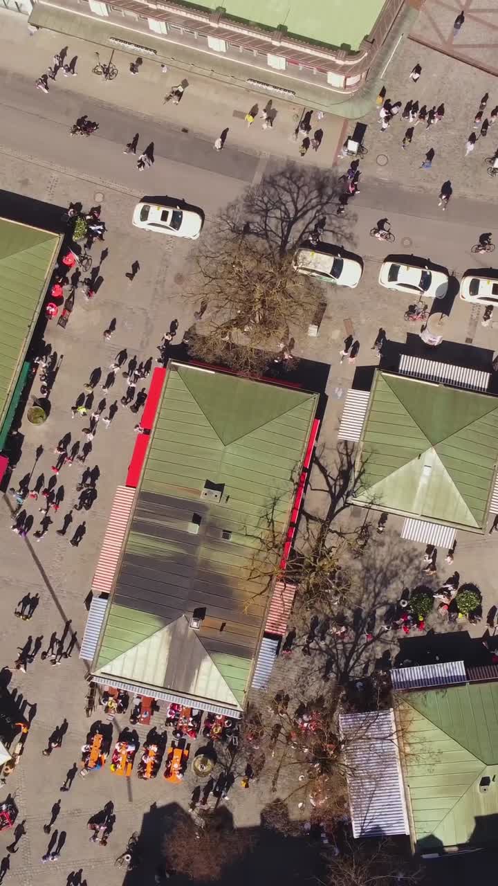 People Walking In The Street Around The Viktualienmarkt, Farmers Market In Munchen, Germany. - aerial vertical shot