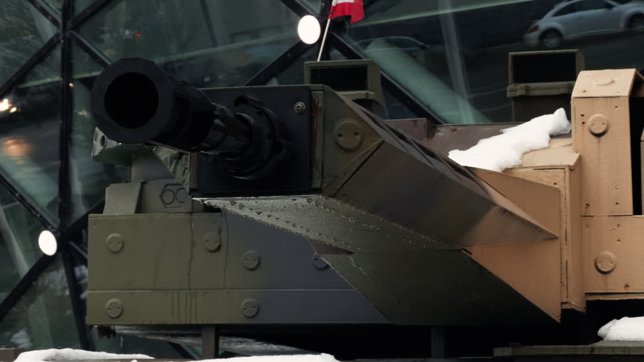 Close-up of an armored personnel carrier cannon in Budapest, showing modern military hardware, urban security presence, and the broader European defense context amid current geopolitical tensions