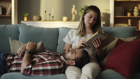 Couple relaxing at home reading a book