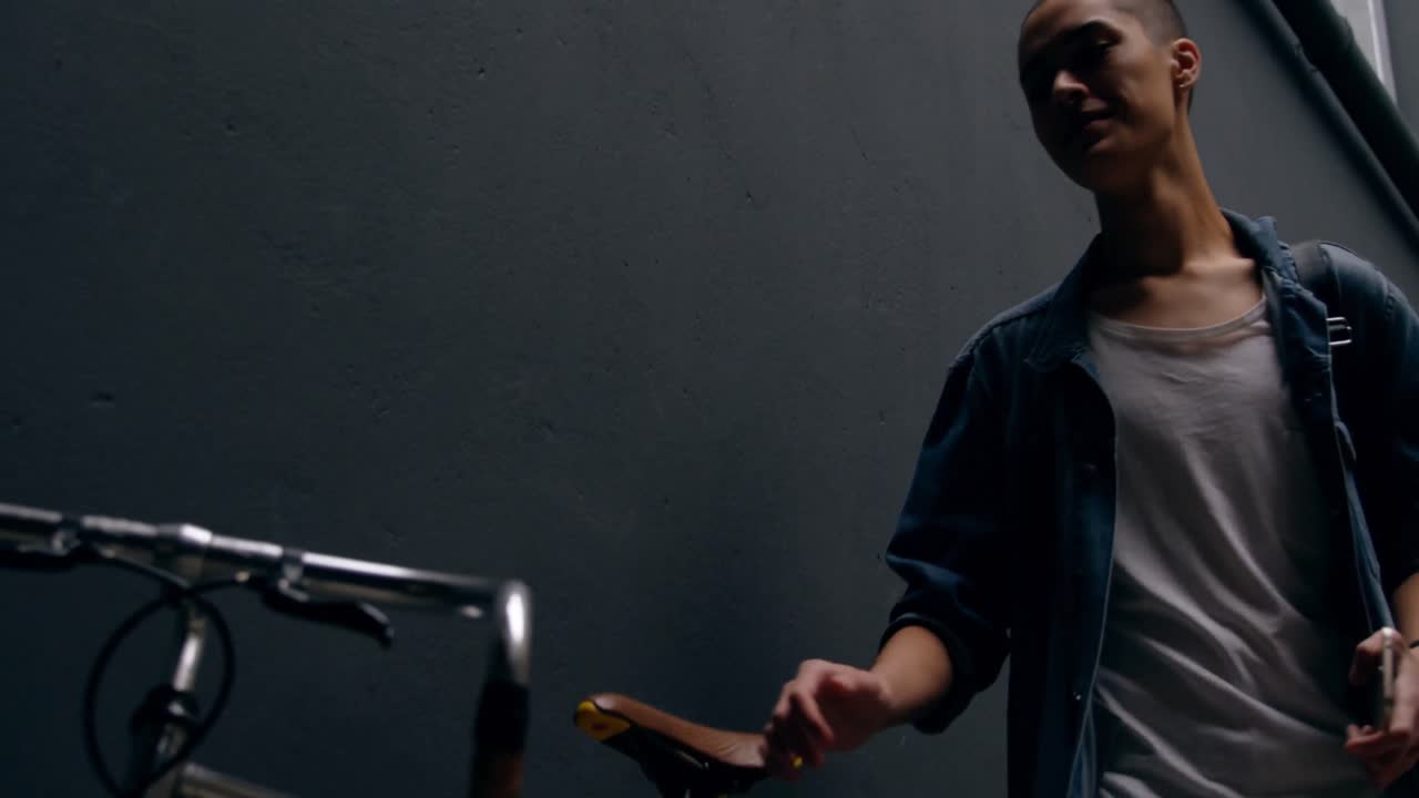 hombre usando teléfono móvil mientras se apoya contra la pared 4k