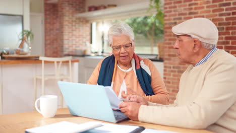 elderly couple discussing financial documents at home