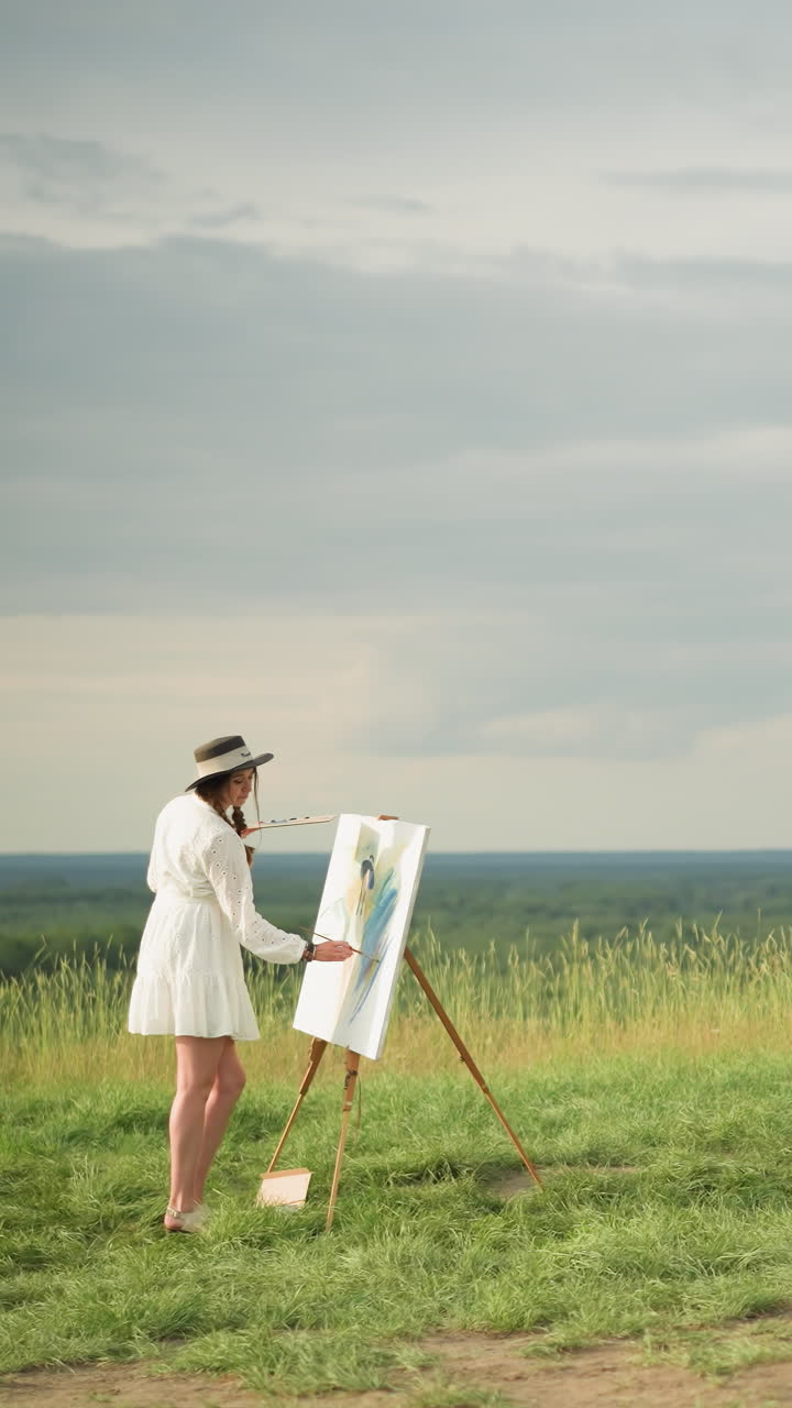 하 드레스를 입은 여자가 손에 팔레트를 들고 캔버스를 칠하는 데 집중하고, 검은 모자와 체크 셔츠를 입은 예술가가 구름이 은 하늘 아래 잔디에 있는 의자를 향해 걸어가고 있습니다.