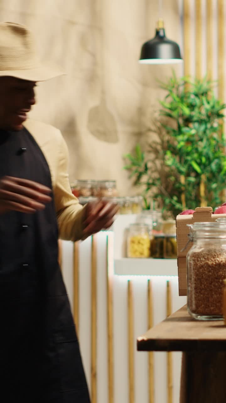 Lokal sælger placerer kasser med frisk høstede frugter i en dagligvarebutik i en lodret video.