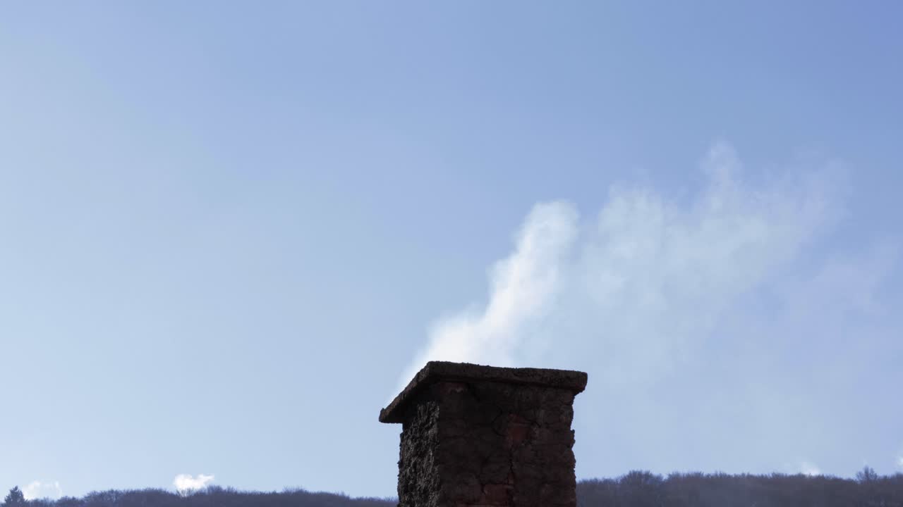 Close up shot of a house chimney with smoke coming out of it