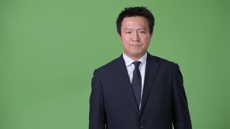 녹색 배경에 성숙한 일본 사업가
