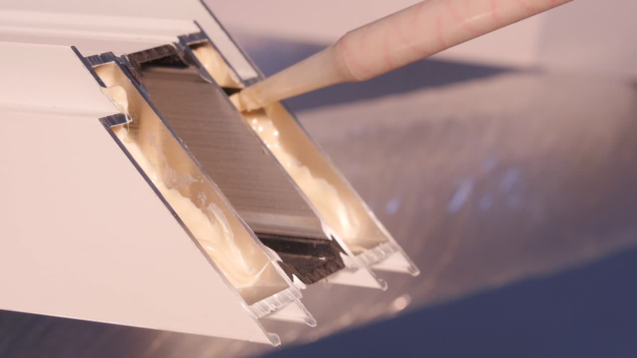 aplicación de sellador adhesivo al perfil de aluminio