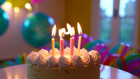 birthday cake with lit candles and party decorations