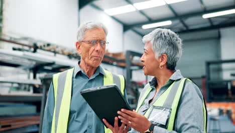 factory workers discussing project on a tablet