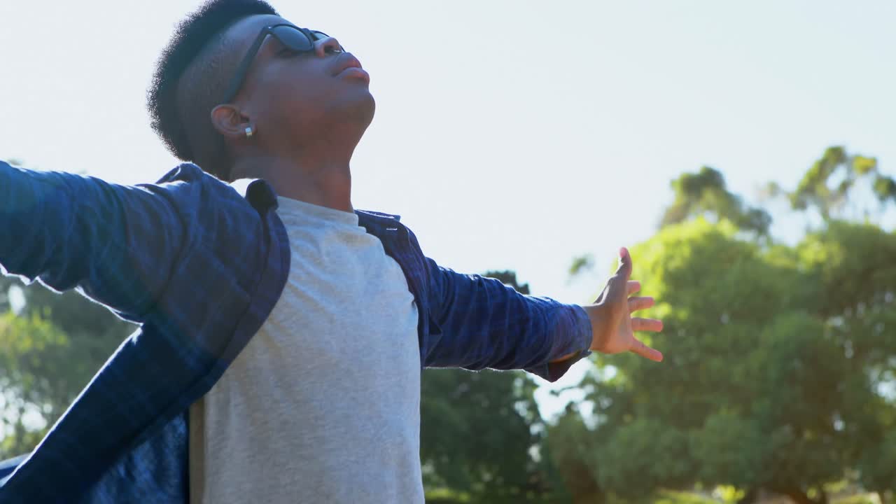 Man standing with arms wide open at festival 4k