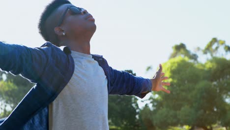 man standing with arms wide open at festival 4k