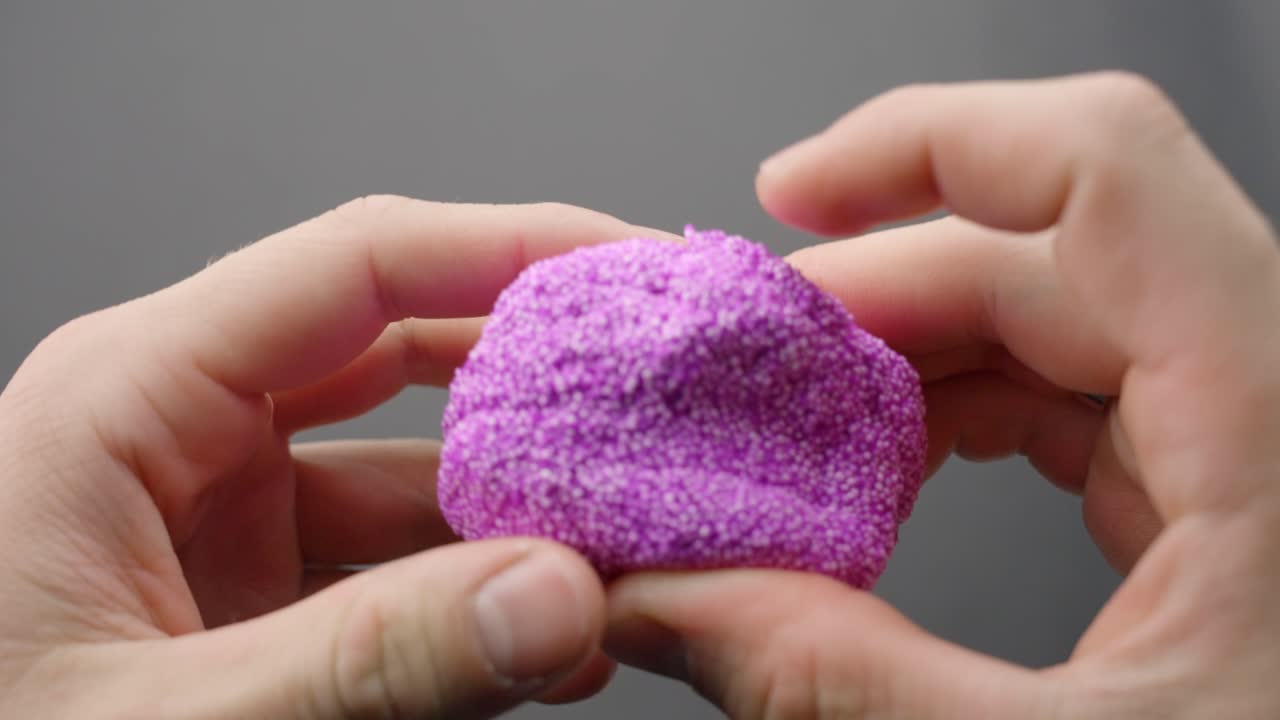 Person squeezing purple floam, POV view