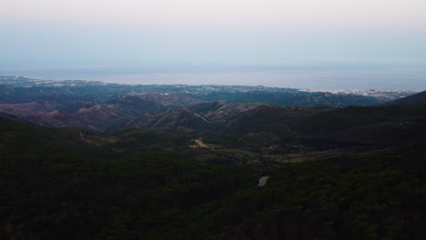 Eine-Drohne-Erhebt-Sich-über-Den-Berghang,-Der-Nach-Estepona,-Spanien-Und-Zur-Küste-Führt