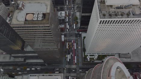 High-angle-ascending-footage-streets-between-high-rise-buildings-in-city-centre.-Vehicles-waiting-in-queues-in-front-of-crossroads.-Manhattan,-New-York-City,-USA