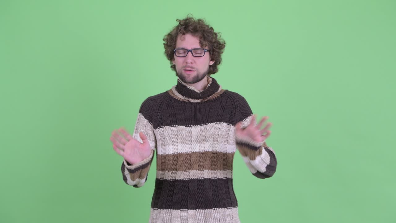 un joven guapo con barba y cabello rizado.