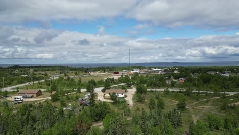 Eine-Sich-Bewegende-Luftdrohnenaufnahme-Eines-Wohngebiets-Und-Eines-Cedar-Lake-In-Der-Region-Easterville-Und-Chemawawin-Cree-Nation-Während-Der-Sommermonate-Und-Der-Bewölkten-Jahreszeit