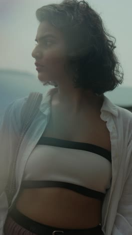 ertical shot of a south asian woman in coastal wear with light flares obscuring part of the frame. india