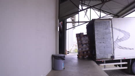 a man loading up a pallet on a docked truck