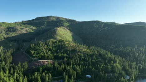 Drone-shot-pulling-away-from-vast-hills,-cleared-for-lumber