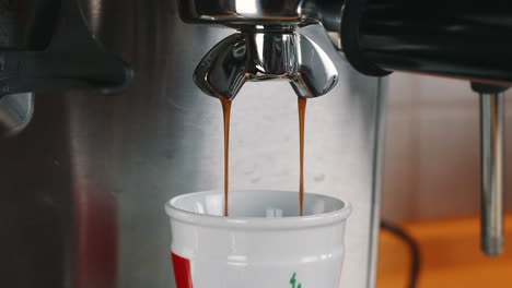 coffee gently flowing into espresso cup in slow motion