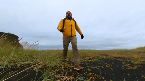 running along reynisfjara black sand beach in the part where there are plants