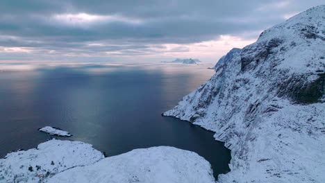 lofoten islands extreme frozen mountain and wintry blue ocean landscape aerial view slowly moving right