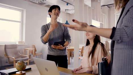 mixed race colleagues talk to female boss. happy millennial workers smile and meet ceo in light trendy office space 4k