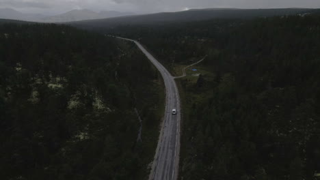 a drone shot of centered road leading symmetrical through a valley
