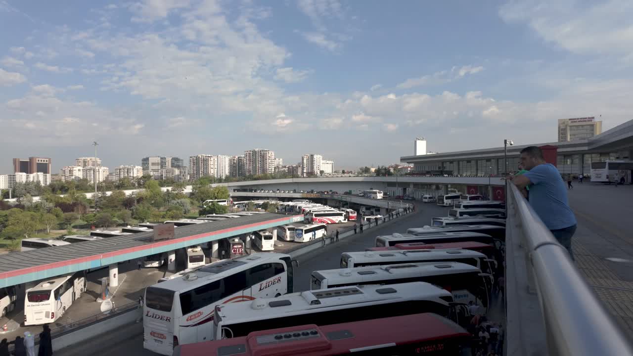 The bustling Ankara Bus Terminal with the city skyline in the background, a hub for Turkey's travelers