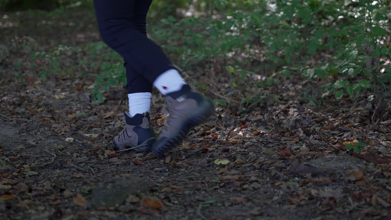 산책 부츠를 입은 가까운 여자 발, 죽은 잎으로 숲을 는