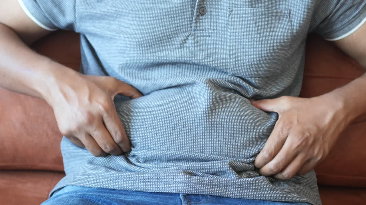 hombre con un vientre grande, demostrando grasa abdominal.