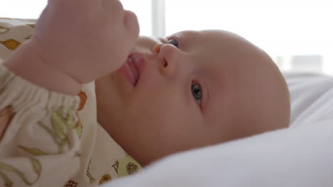 Portrait-of-baby-girl-lying-on-bed