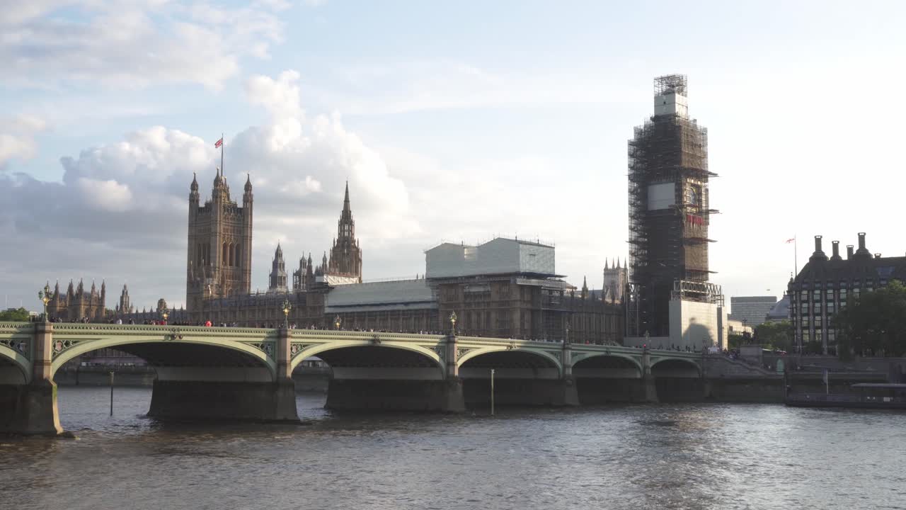 Big Ben in reconstruction and Westminster bridge full of people, London