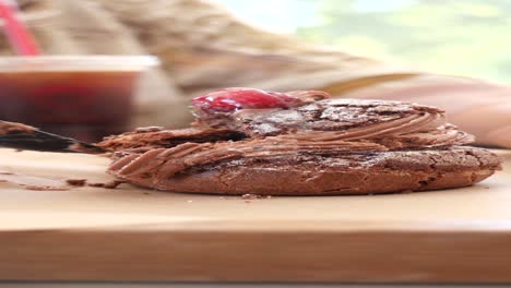 a person enjoying a chocolate cake with whipped cream and cherry on top