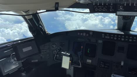 vista de la cabina del jet desde el lado del capitán, luz del día, mientras sobrevuela algunas nubes