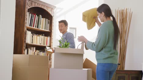 video of happy diverse couple unpacking boxes after moving in