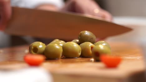 picar aceitunas en una tabla de cortar