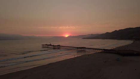 increíble puesta de sol sobre un muelle, toma aérea con movimiento ascendente