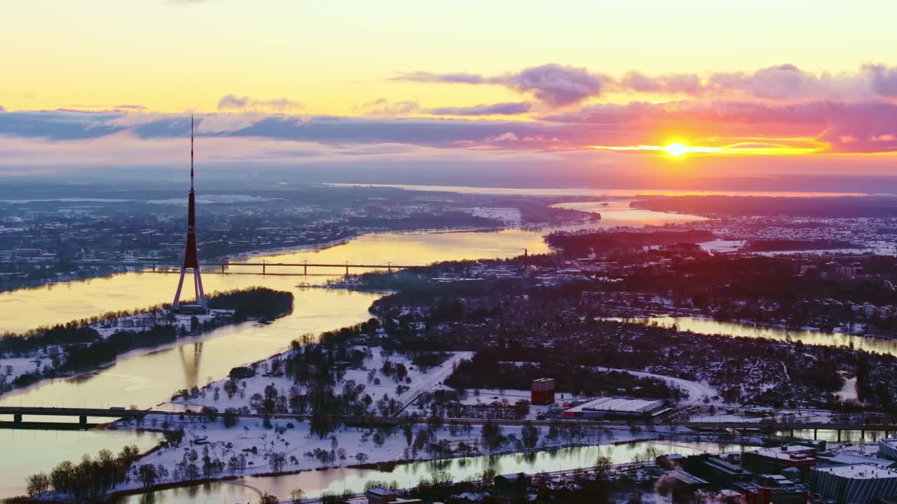 Golden light fills icy Riga landscape as sun rises behind Latvian TV Tower