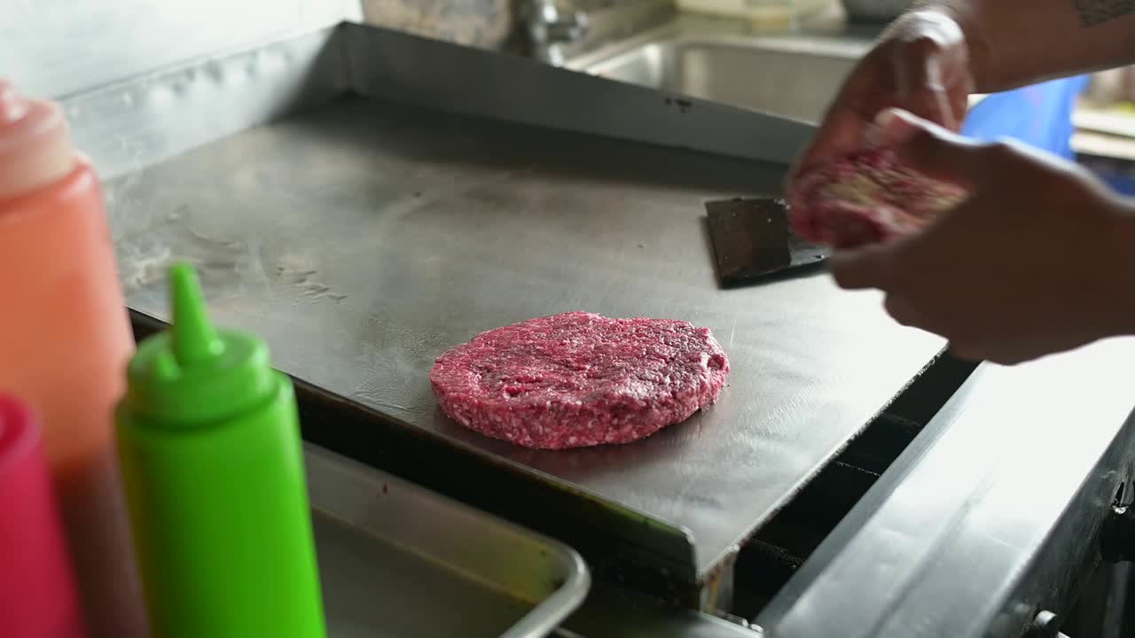 cocinero irreconocible cocinando chuletas para hamburguesas en superficie caliente