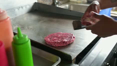 unrecognizable chef cooking cutlets for hamburgers on hot surface