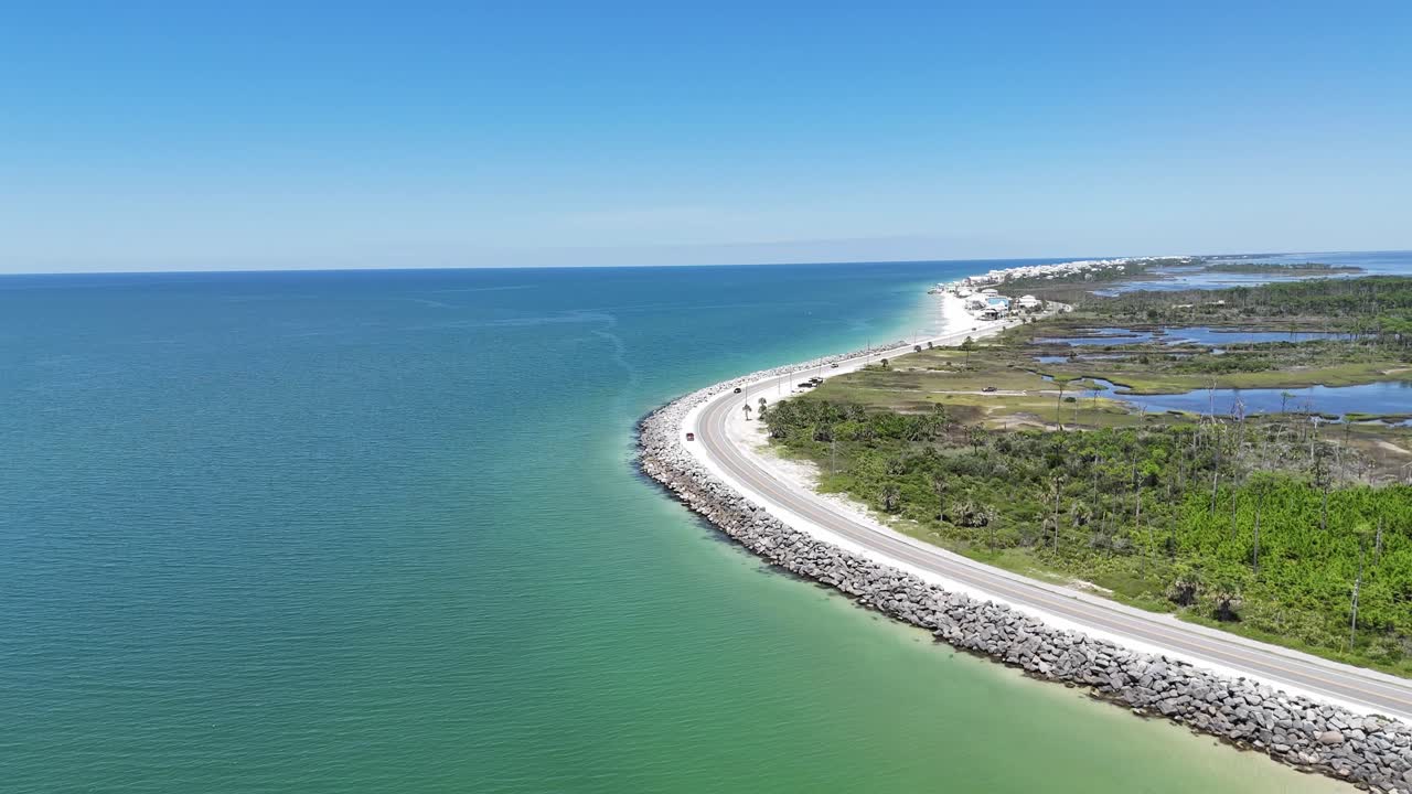 Forward drone fly near the curving coastline road and over the beautiful open ocean, Cape San Blas, Gulf County, Florida, USA
